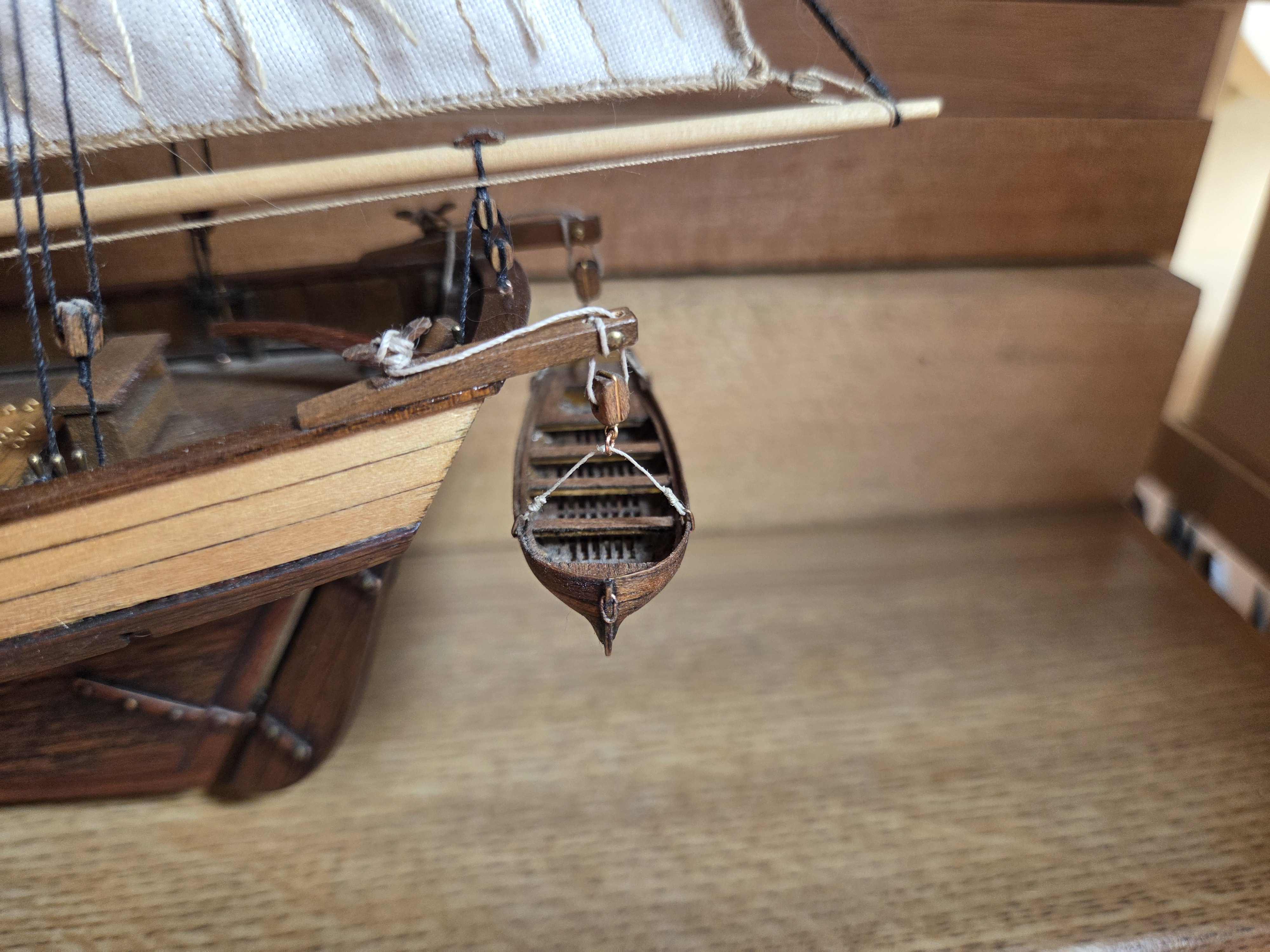 The ship's boat hung from its davit on scale rope falls