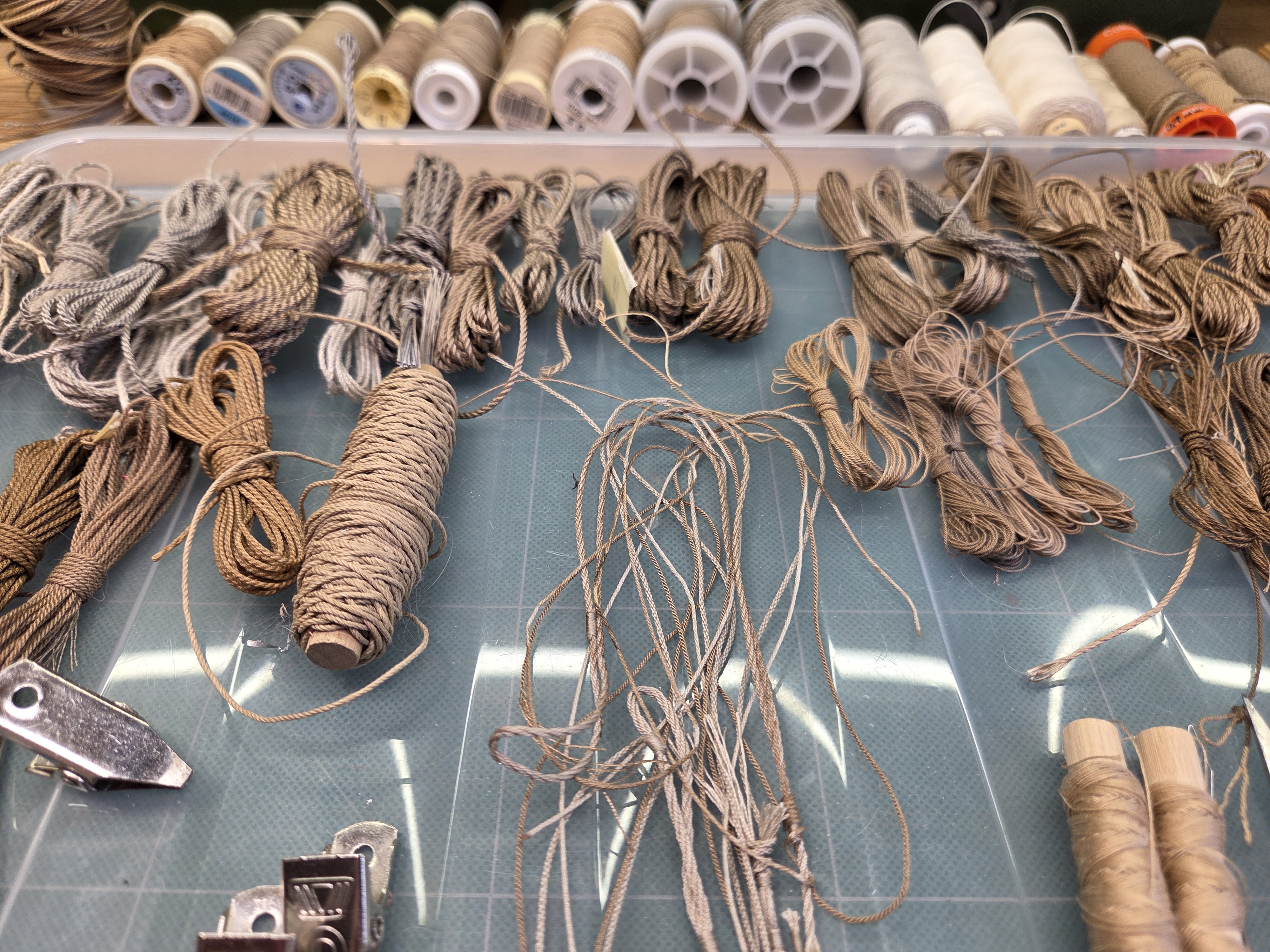 A tray of finished rope hanks with the thread spools they were laid from